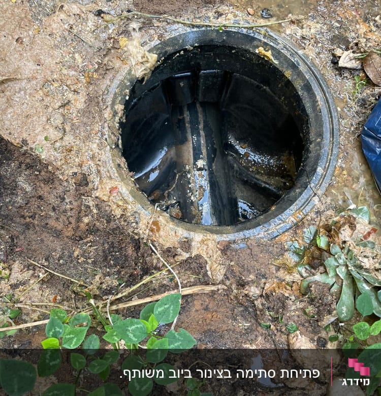 פתח ביוב פתוח עם אדמה רטובה מסביב